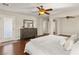 Large main bedroom boasts hardwood floors, ceiling fan, dresser and entry to bathroom at 10133 Longoria St, Las Vegas, NV 89178