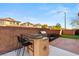 Outdoor cooking area with grill, bar seating, and artificial turf in backyard at 10133 Longoria St, Las Vegas, NV 89178