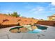 A calming backyard pool reflects the sky with colorful decor on the brick wall at 10133 Longoria St, Las Vegas, NV 89178
