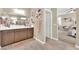 Well lit bathroom featuring a double vanity with storage and framed decorative wall art at 10792 Crestview Pointe Ave, Las Vegas, NV 89166