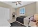 Cozy bedroom with plush bedding, ceiling fan, desk, and bright natural light from the window at 10792 Crestview Pointe Ave, Las Vegas, NV 89166