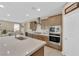 Open concept kitchen offering bar seating, modern stainless steel appliances, and abundant cabinet storage at 10792 Crestview Pointe Ave, Las Vegas, NV 89166