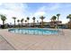 Relaxing community pool area with sun loungers, palm trees, and a clear blue swimming pool at 12367 Indigo Montage Rd # 3, Las Vegas, NV 89183