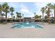 Relaxing community pool surrounded by palm trees, lounge chairs and umbrellas at 12367 Indigo Montage Rd # 3, Las Vegas, NV 89183