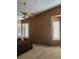 Spacious bedroom with neutral carpet and dark brown textured accent wall, shuttered windows, and ceiling fan at 1255 Del Lilly Ln, Las Vegas, NV 89123