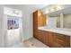Bathroom with wood cabinets, a sink, and a mirror with great lighting at 200 W Sahara Ave # 3004, Las Vegas, NV 89102