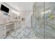 Modern bathroom featuring marble floors, vanity with seating area, and glass enclosed shower at 2101 Diamond Bar Dr, Las Vegas, NV 89117