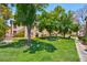 The community has a green lawn area with picnic tables and trees offering shade on a sunny day at 2110 Los Feliz St # 1037, Las Vegas, NV 89156