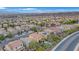 An aerial view of a neighborhood home with a pool, spa, covered patio, and desert landscaping in the backyard at 2445 Rue Royale, Henderson, NV 89044