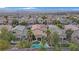 An aerial view shows a neighborhood home with a pool, spa, covered patio, and desert landscaping at 2445 Rue Royale, Henderson, NV 89044