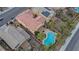 An aerial view of a neighborhood home with a pool, spa, covered patio, and mature landscaping at 2445 Rue Royale, Henderson, NV 89044