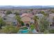 An aerial view shows a neighborhood home with a pool, spa, covered patio, and desert landscaping at 2445 Rue Royale, Henderson, NV 89044