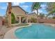 An amazing backyard shows the pool, landscaping, covered patio, and view of the home at 2445 Rue Royale, Henderson, NV 89044