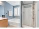 Modern bathroom with a soaking tub and glass-enclosed shower, illuminated by natural light at 2445 Rue Royale, Henderson, NV 89044