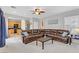 Open living room with a leather sectional sofa, ceiling fan, and neutral decor at 2445 Rue Royale, Henderson, NV 89044