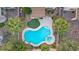 The aerial view of a backyard features a large, bright blue pool, spa, and artificial turf at 2445 Rue Royale, Henderson, NV 89044