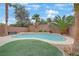 Backyard oasis with a sparkling pool, mature landscaping, and lush artificial turf at 2445 Rue Royale, Henderson, NV 89044