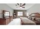 Relaxing primary bedroom with a ceiling fan, dresser, full-length mirror, and a luxurious king-sized bed at 2539 Ballatore St, Henderson, NV 89044