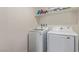 The laundry room has white machines and a shelf for detergent at 2901 Bahama Yellow Ave, North Las Vegas, NV 89086