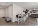 Open-concept living room with modern furniture, dining table, and gray wood-look vinyl flooring at 2901 Bahama Yellow Ave, North Las Vegas, NV 89086