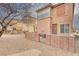 Property backyard with peach colored facade, low brick wall, and desert landscaping at 3525 Hammock St, Las Vegas, NV 89147