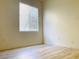 Bright bedroom with wood-look flooring, fresh paint, a window with mini blinds, and modern baseboards at 3525 Hammock St, Las Vegas, NV 89147