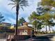 Community guard house near the entrance to the neighborhood surrounded by trees and lush landscaping at 3525 Hammock St, Las Vegas, NV 89147