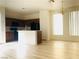 Open kitchen design with wood cabinets, black appliances, and an adjacent dining area filled with light at 3525 Hammock St, Las Vegas, NV 89147