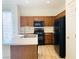 Functional kitchen with wood cabinets, an island, and black appliances creates a practical cooking space at 3525 Hammock St, Las Vegas, NV 89147