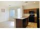 Efficient kitchen featuring black appliances, wood cabinetry, and a functional layout with an island at 3525 Hammock St, Las Vegas, NV 89147