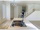 Bright kitchen view featuring stainless steel sink, adjacent to the wooden staircase at 3525 Hammock St, Las Vegas, NV 89147