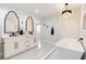 A stylish bathroom featuring double vanities, custom mirrors and a freestanding tub at 3645 E Viking Rd, Las Vegas, NV 89121