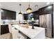 Modern kitchen featuring dark cabinetry, stainless steel appliances, and a sleek island with pendant lighting at 3645 E Viking Rd, Las Vegas, NV 89121