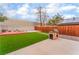 Spacious backyard featuring an outdoor kitchen, patio, artificial grass, and a wooden fence at 3744 Archer St, Las Vegas, NV 89108