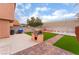 A backyard with an outdoor kitchen, red brick patio and low maintenance artificial grass at 3744 Archer St, Las Vegas, NV 89108