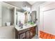 Bathroom featuring a large mirror, single vanity with dark cabinets and access to the toilet at 3744 Archer St, Las Vegas, NV 89108