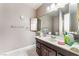 Bathroom featuring a large mirror, single vanity with dark cabinets, and light colored tile at 3744 Archer St, Las Vegas, NV 89108