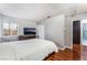 Bedroom featuring a window, white comforter, wood flooring and a television at 3744 Archer St, Las Vegas, NV 89108