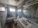 Modern bathroom featuring marbled walls, a tub-shower, and a white vanity with undermount sink at 4342 E Russell Rd, Las Vegas, NV 89120