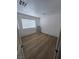 Simple bedroom with light wood floors, white walls, and large window with blinds at 4342 E Russell Rd, Las Vegas, NV 89120