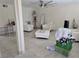 Living room features tile floors, white chairs and ottomans, large fan, and decor at 4342 E Russell Rd, Las Vegas, NV 89120