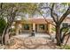 A serene backyard featuring a covered patio with a grill, complemented by trees and gravel landscaping at 5029 Alfingo St, Las Vegas, NV 89135
