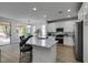 Modern kitchen with marble countertops, an island with seating, white cabinetry and opens up to the dining area at 5029 Alfingo St, Las Vegas, NV 89135