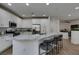 Bright kitchen with stainless steel appliances, marble countertops, an island with seating, and modern fixtures at 5029 Alfingo St, Las Vegas, NV 89135