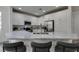 An island in the kitchen offers seating and adds style with its marble countertops, stainless appliances, and white cabinets at 5029 Alfingo St, Las Vegas, NV 89135