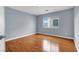 Bright bedroom featuring hardwood floors and a window letting in natural light at 5246 Aurora Beam Ave, Las Vegas, NV 89122