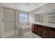 Bathroom featuring a glass-enclosed shower, a soaking tub, and a double vanity with modern fixtures at 5691 Tinar St, Las Vegas, NV 89113