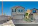This two-story residence features an attached garage and well-maintained landscaping adding curb appeal at 5691 Tinar St, Las Vegas, NV 89113