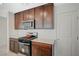Galley kitchen featuring dark wood cabinets, stainless steel appliances, and bright countertops at 5691 Tinar St, Las Vegas, NV 89113