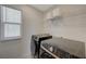 Modern laundry room featuring a full-sized washer and dryer, along with ample shelving for storage at 5691 Tinar St, Las Vegas, NV 89113